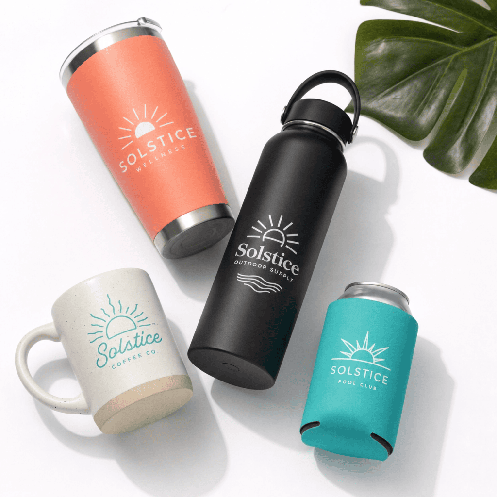 Set of branded Solstice drinkware including a black water bottle, a coral tumbler, a white mug, anda.
